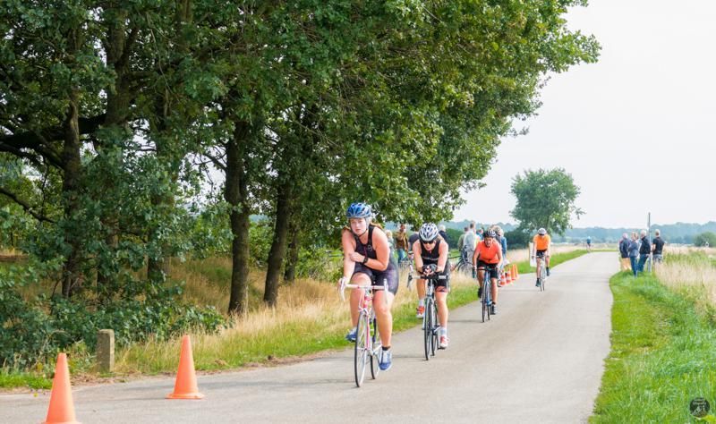 Een groep mensen fietst over een weg.