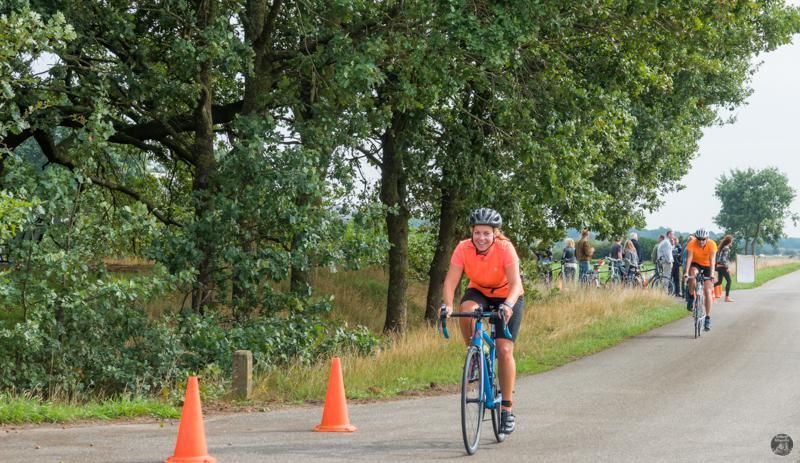Een groep mensen fietst over een weg.