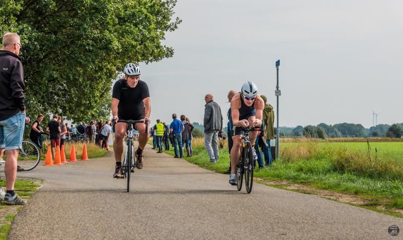 Een groep mensen fietst over een weg.