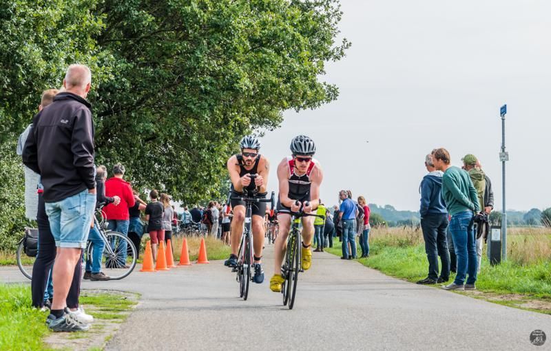 Een groep mensen fietst over een weg.