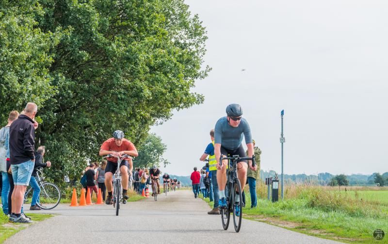 Een groep mensen fietst over een weg.