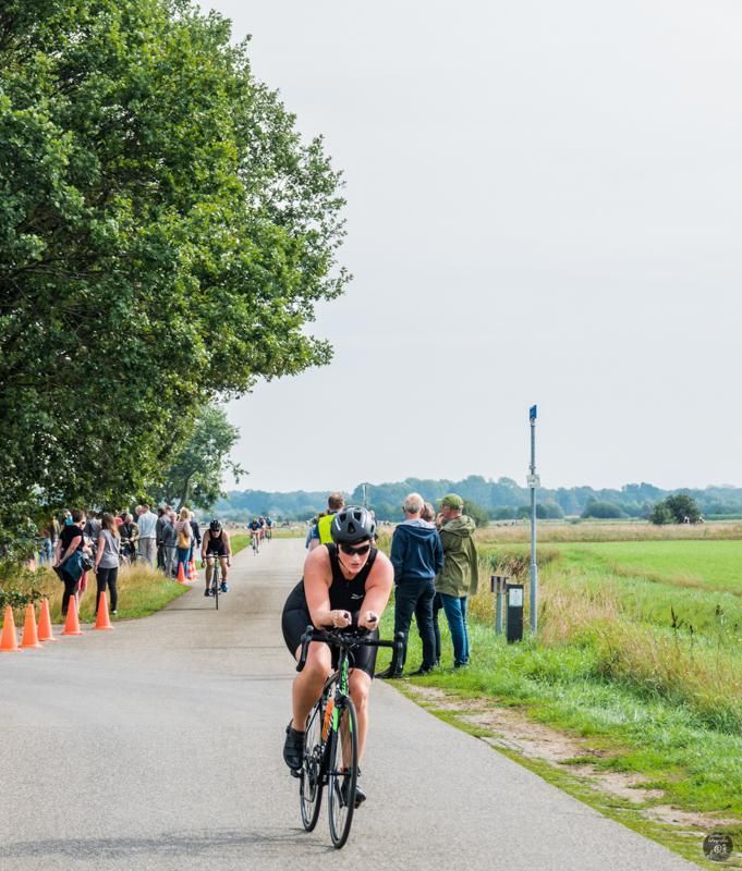 Een man fietst over een weg voor een menigte mensen