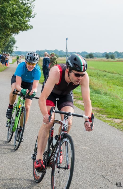 Twee mannen fietsen over een weg.