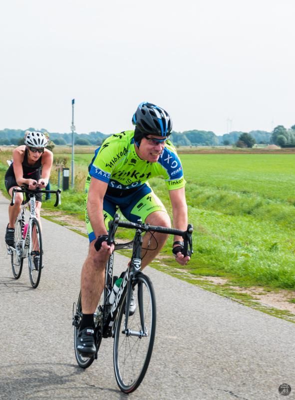 Een man en een vrouw fietsen over een weg.