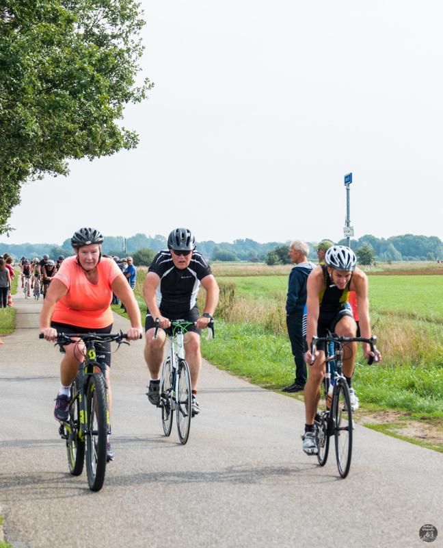Een groep mensen fietst over een weg