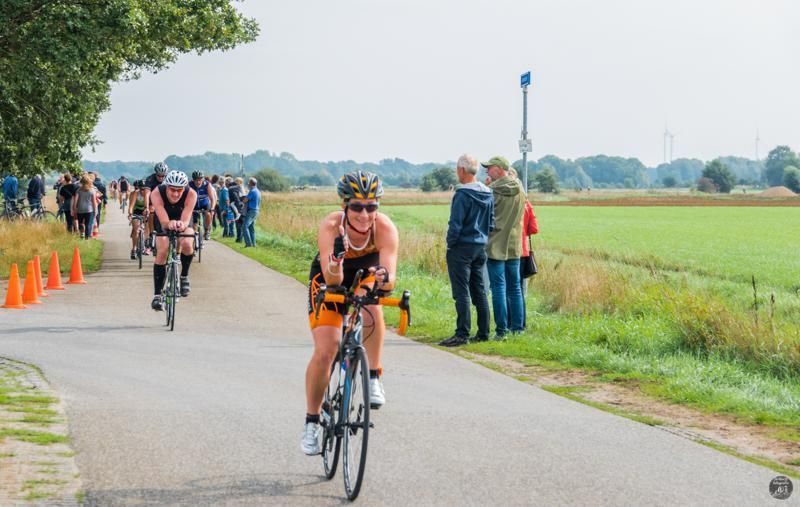 Een groep mensen fietst over een weg.