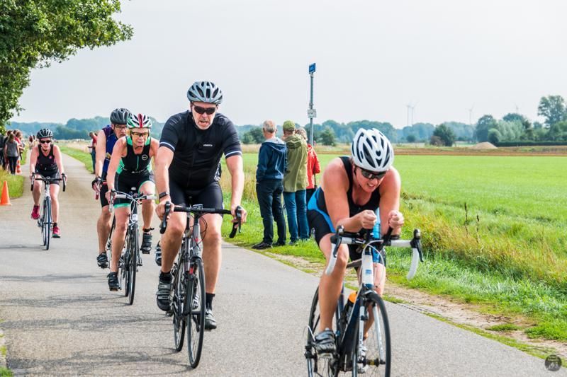Een groep mensen fietst over een weg.