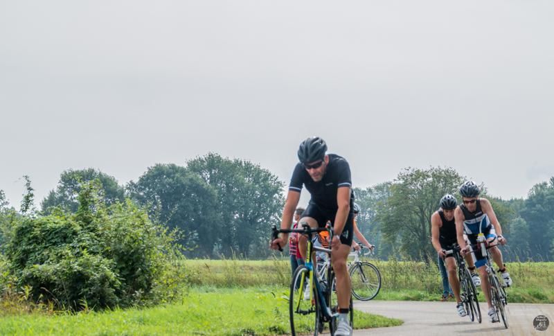 Een groep mensen fietst over een weg.