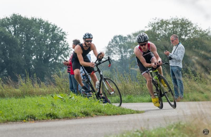 Twee mannen fietsen over een weg.