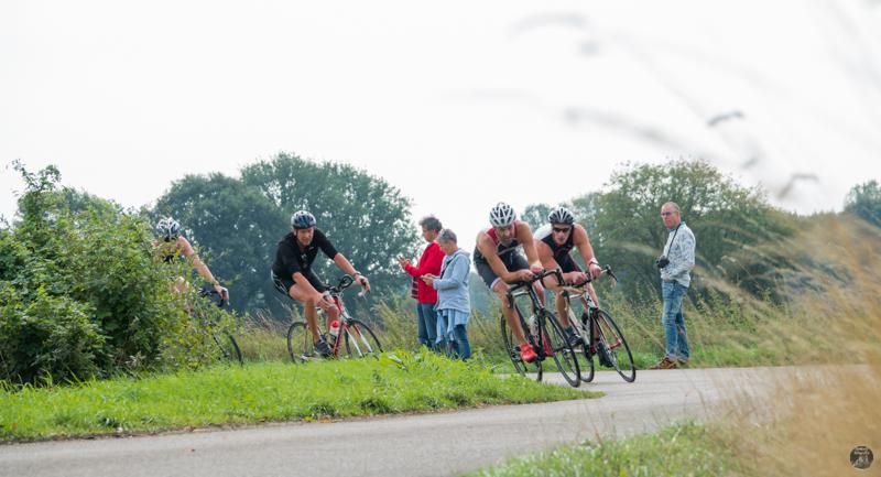 Een groep mensen fietst over een weg.
