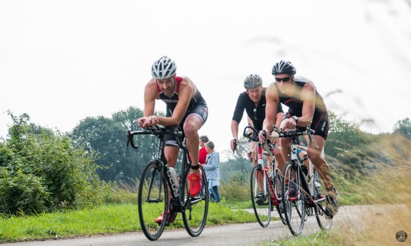 Een groep mensen fietst over een weg.