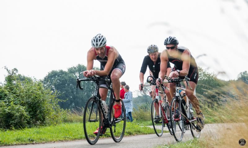 Een groep mensen fietst over een weg.