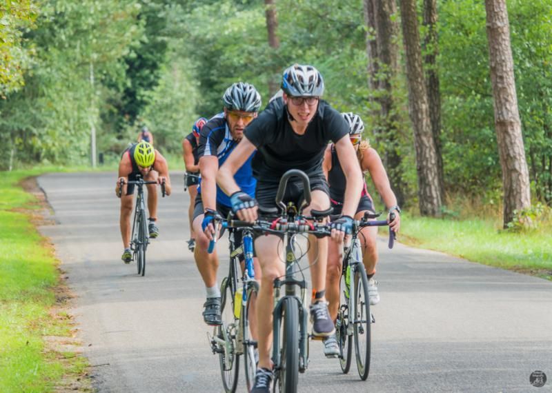 Een groep mensen fietst over een weg.