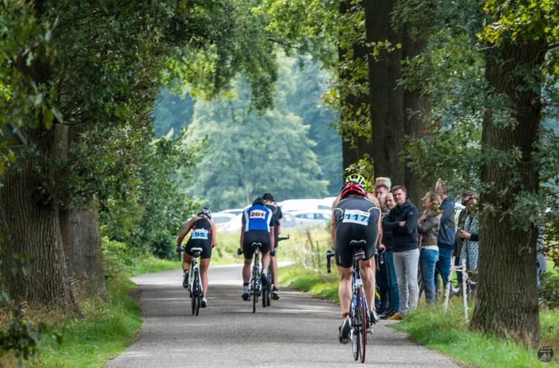 Een groep mensen fietst over een weg.