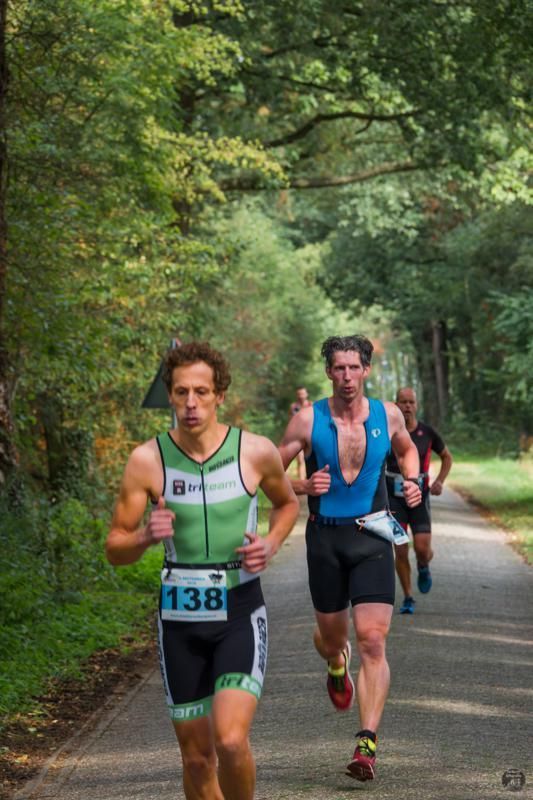Een groep mannen rent een marathon op een pad.