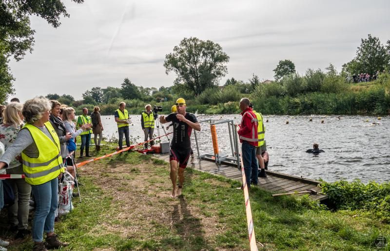Een man rent een triatlon voor een publiek.