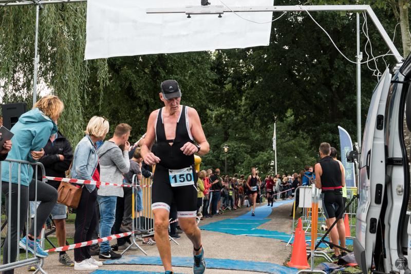 Een man rent mee in een triatlon met het nummer 150 op zijn shirt.