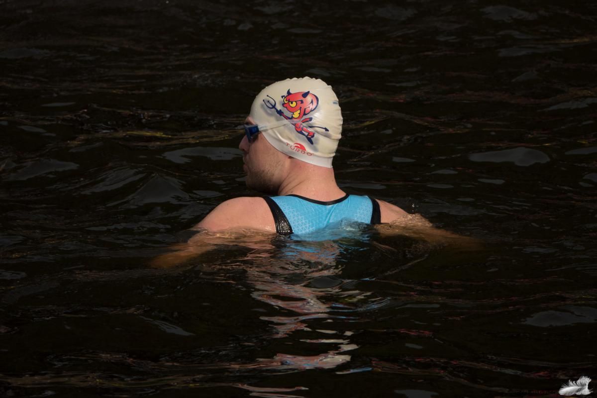 Een persoon die een badmuts draagt, zwemt in het water