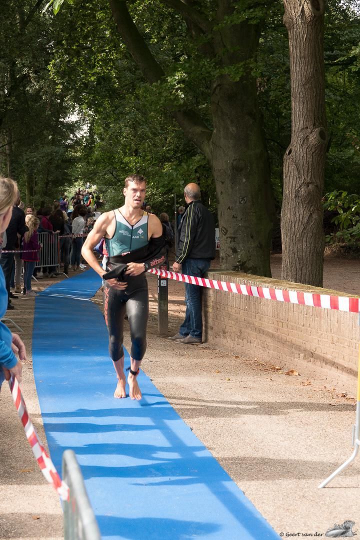 Een man rent op een blauwe mat tijdens een triatlon.