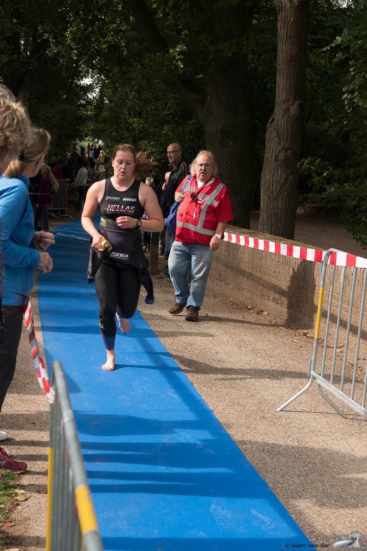 Een vrouw rent op een blauwe loper tijdens een triatlon.
