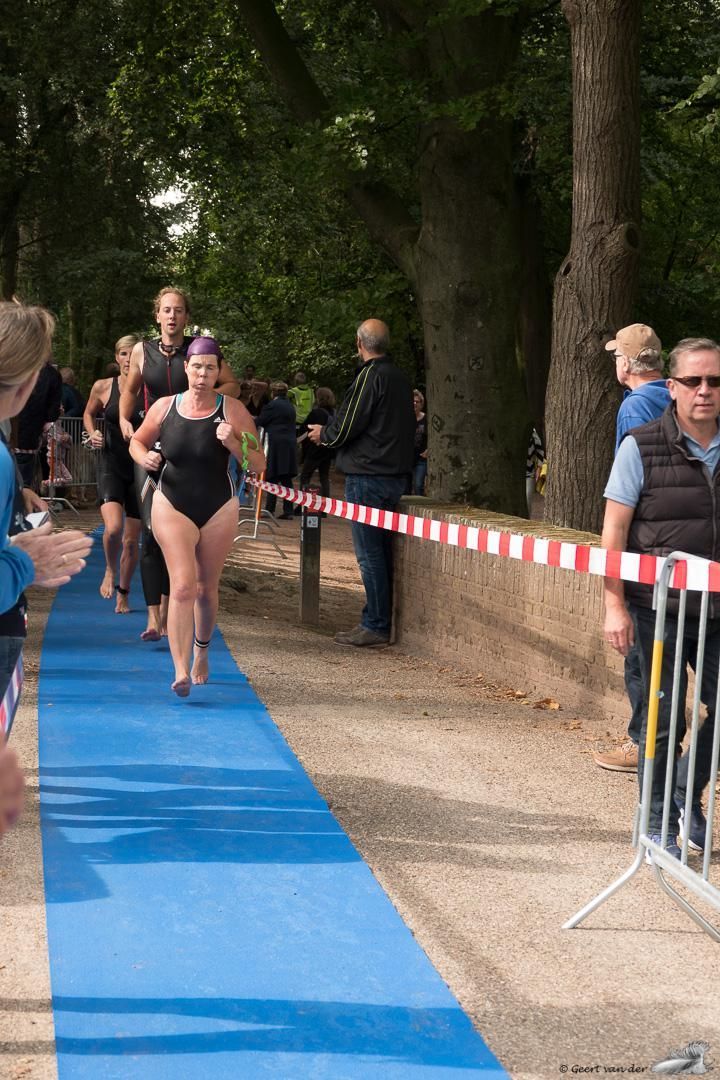 Een groep mensen loopt over een blauwe loper.