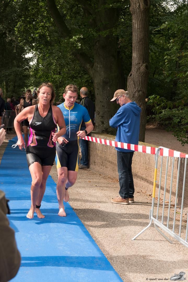 Een groep mensen rent op een blauwe mat.