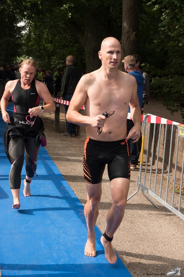 Een man en een vrouw rennen op een blauwe mat