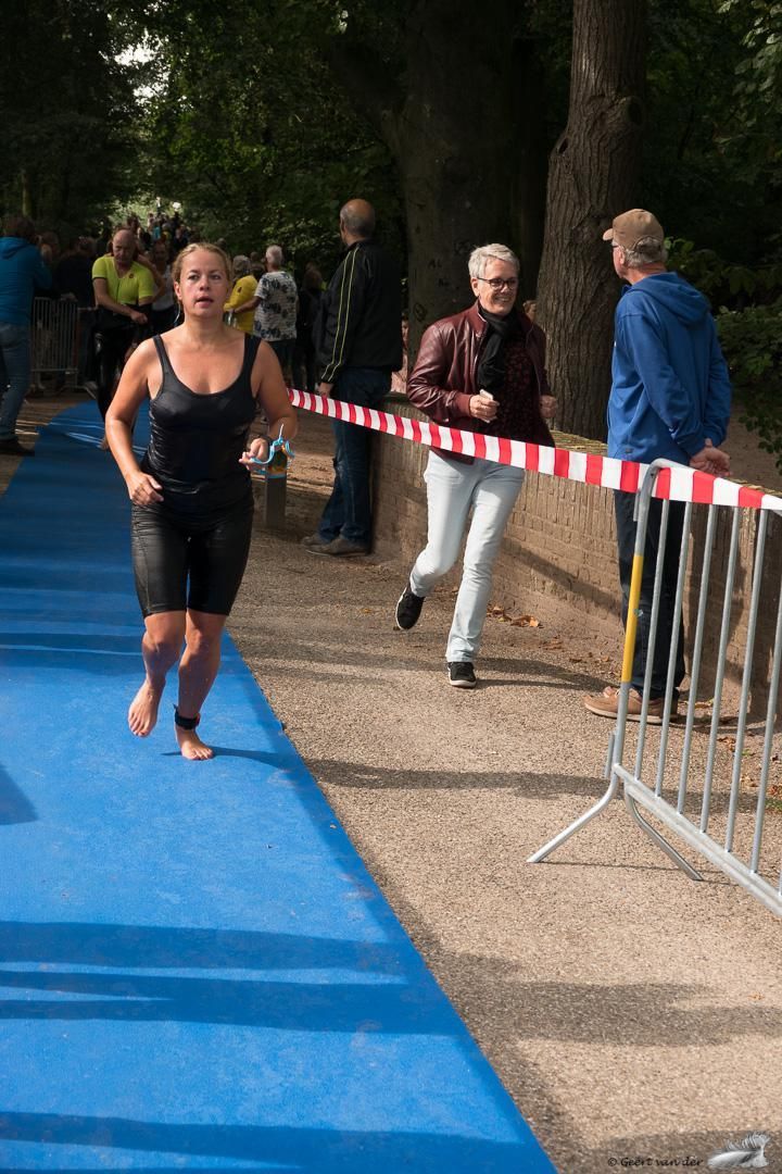 Een vrouw rent op blote voeten over een blauw tapijt.