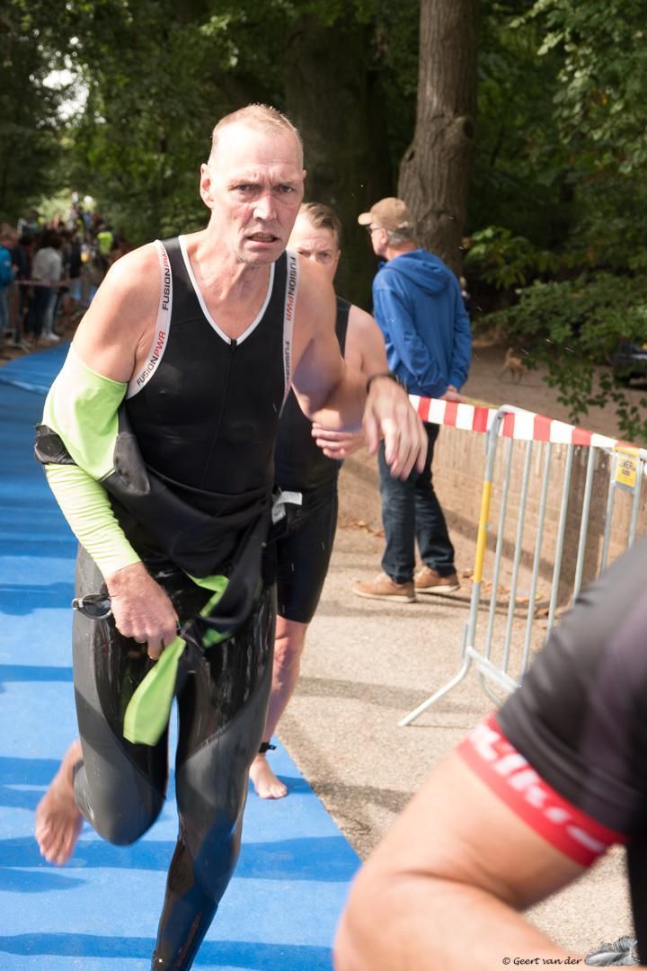 Een man in een wetsuit doet mee aan een race