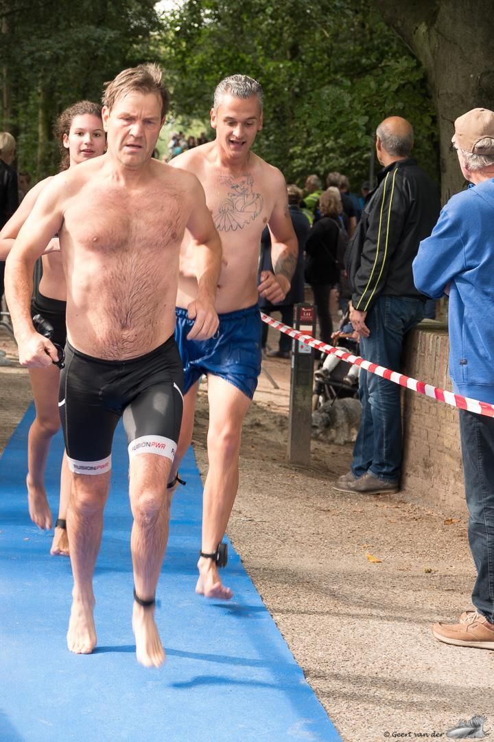 Een groep mannen rent op een blauwe mat.