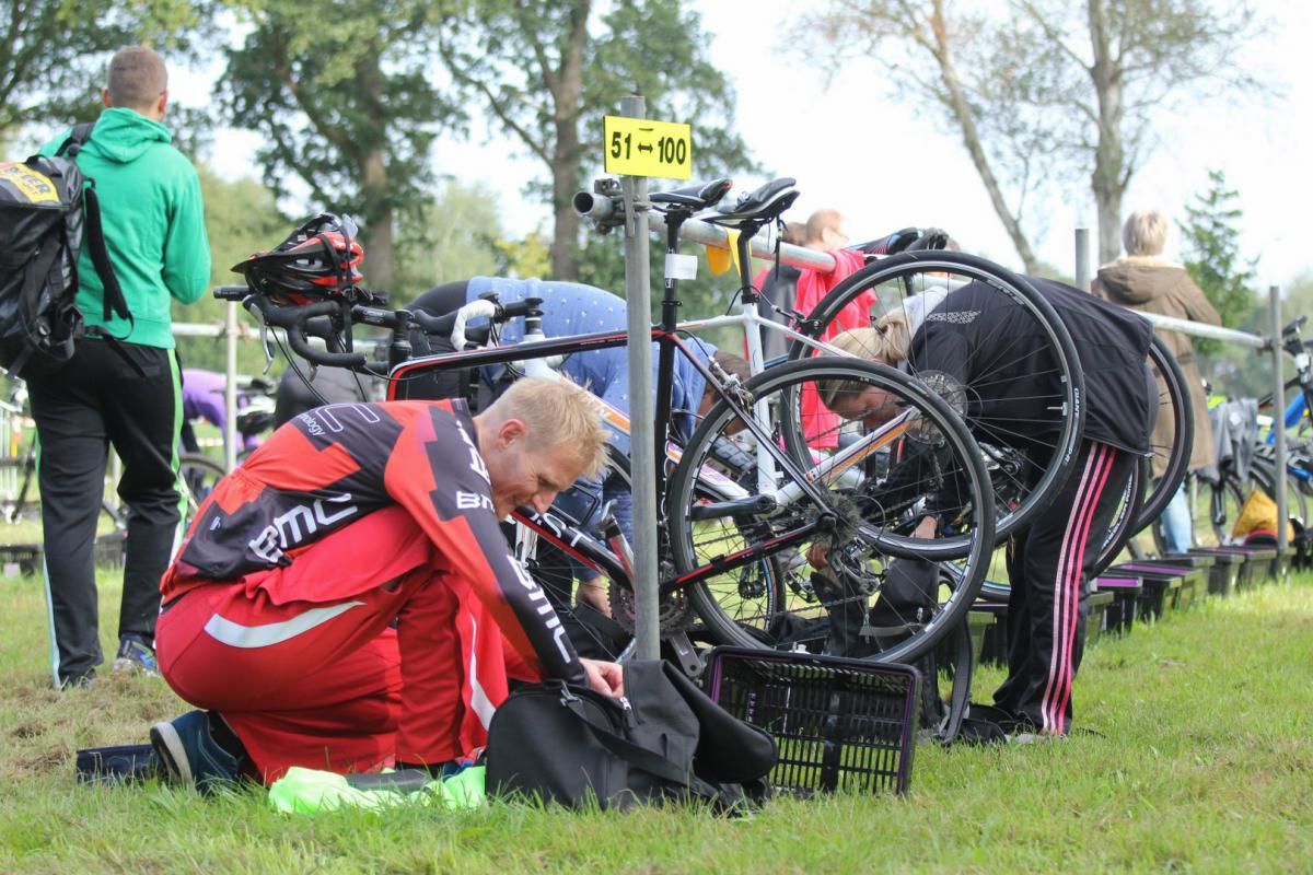 Een groep mensen werkt op een veld aan fietsen.