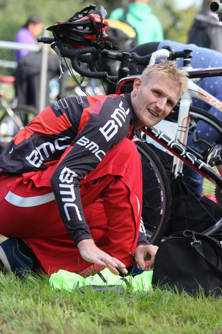 Een man met een bmc-shirt werkt aan een fiets