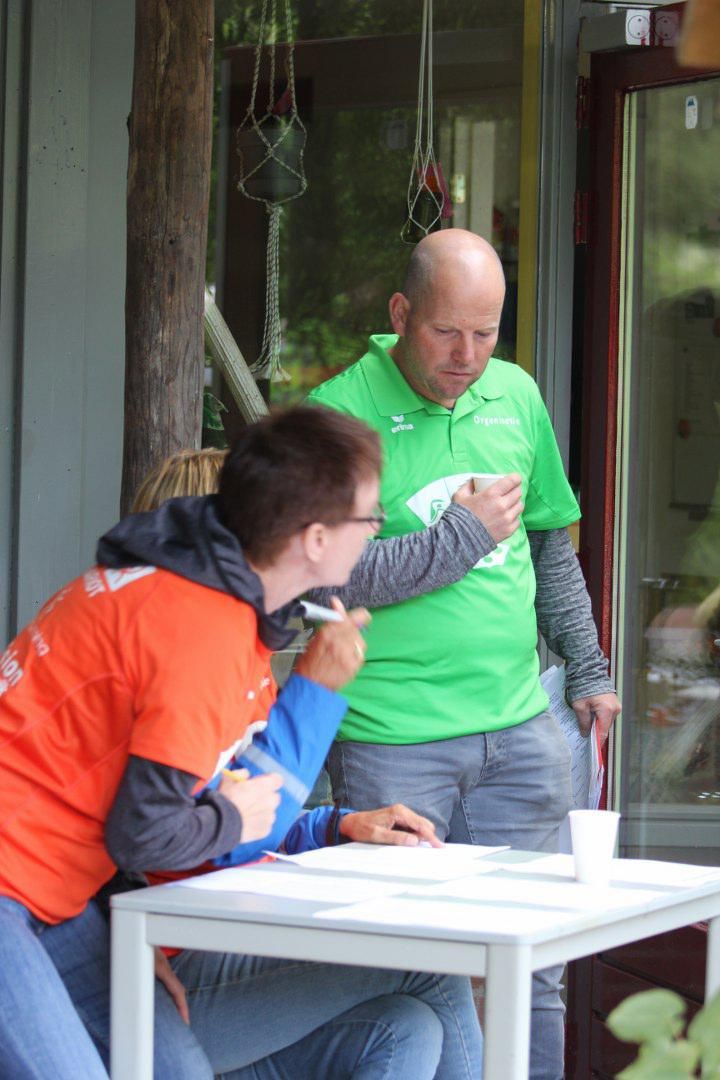Een groep mensen zit aan een tafel en praat met elkaar.