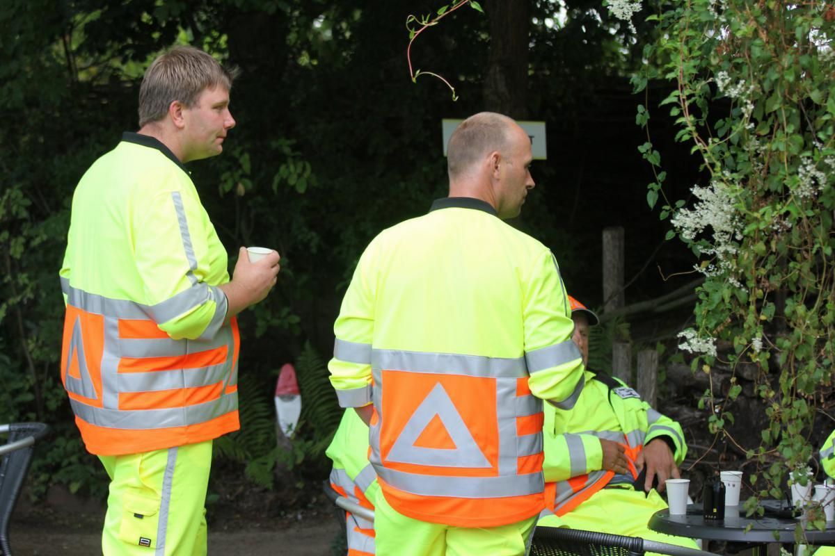 Een groep mannen die veiligheidsvesten dragen met een driehoek op de rug