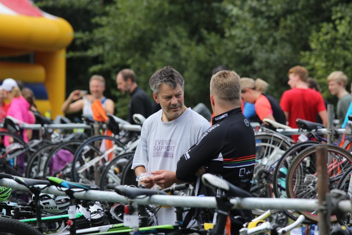 Twee mannen staan ​​te praten voor een stel fietsen.
