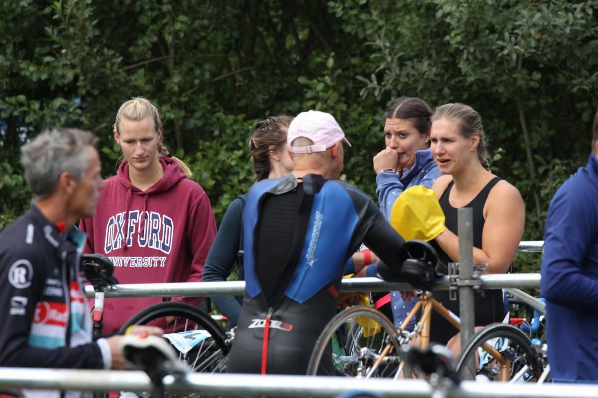 Een man die een sweatshirt draagt ​​met de tekst oxford spreekt tot een groep mensen