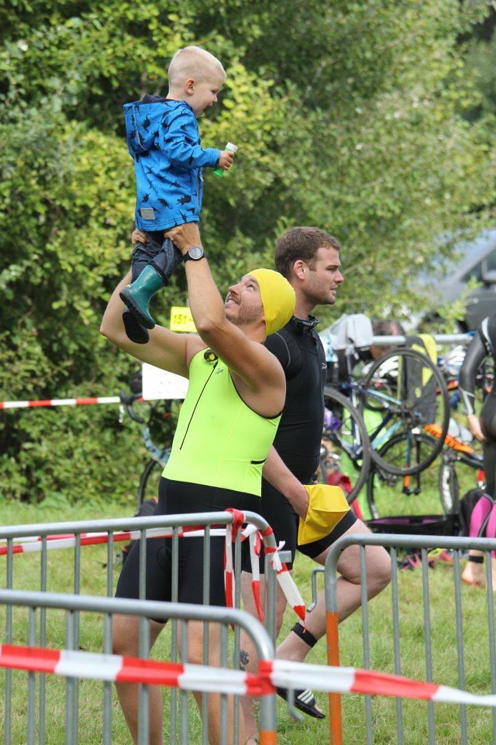 Een man houdt een baby in zijn armen.