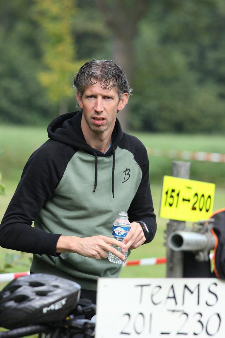 Een man die naast een bord staat met de tekst teams 201 230