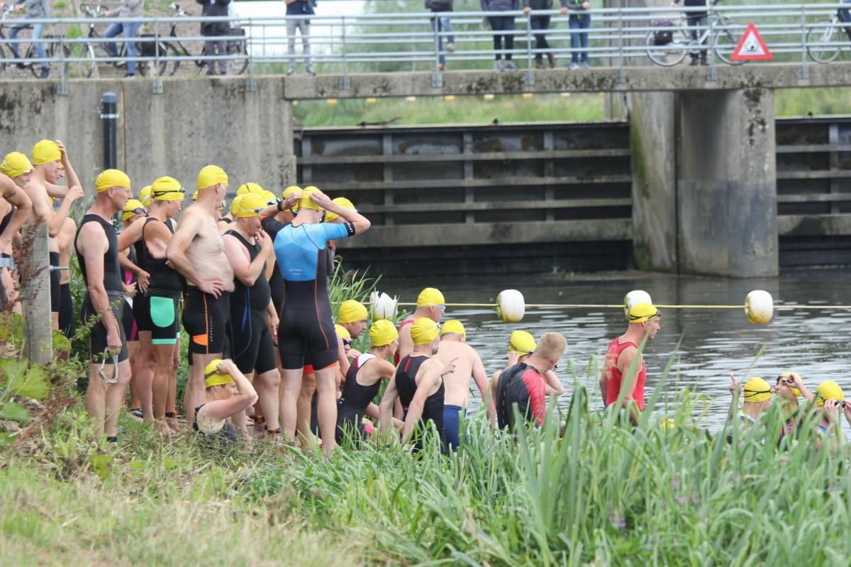 Een groep mensen maakt zich klaar om in een rivier te gaan zwemmen.
