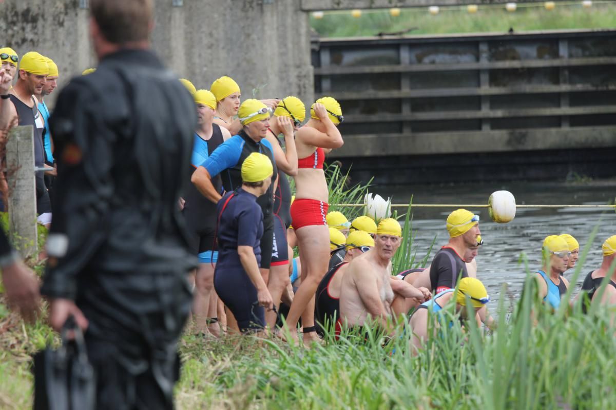 Een groep mensen maakt zich klaar om in een rivier te gaan zwemmen.