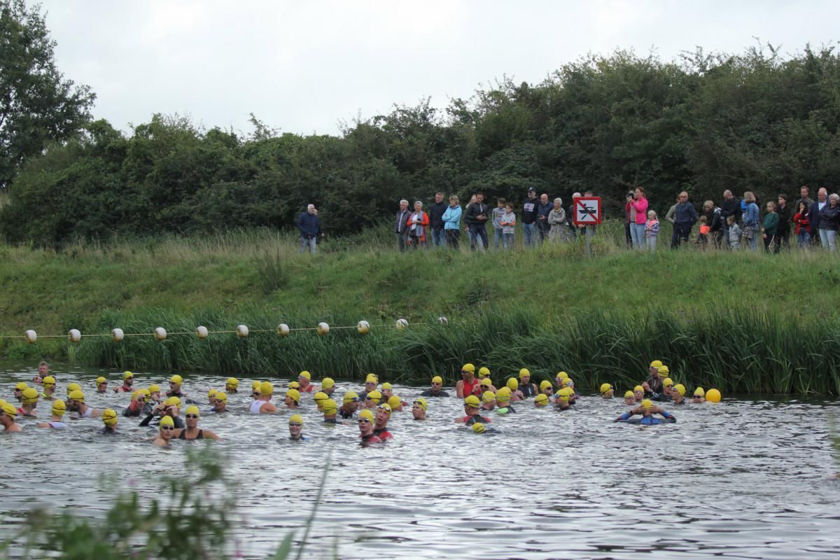 Een groep mensen zwemt in een watermassa.