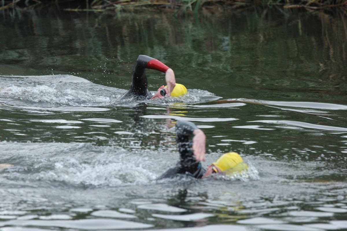 Twee mensen zwemmen in een watermassa.