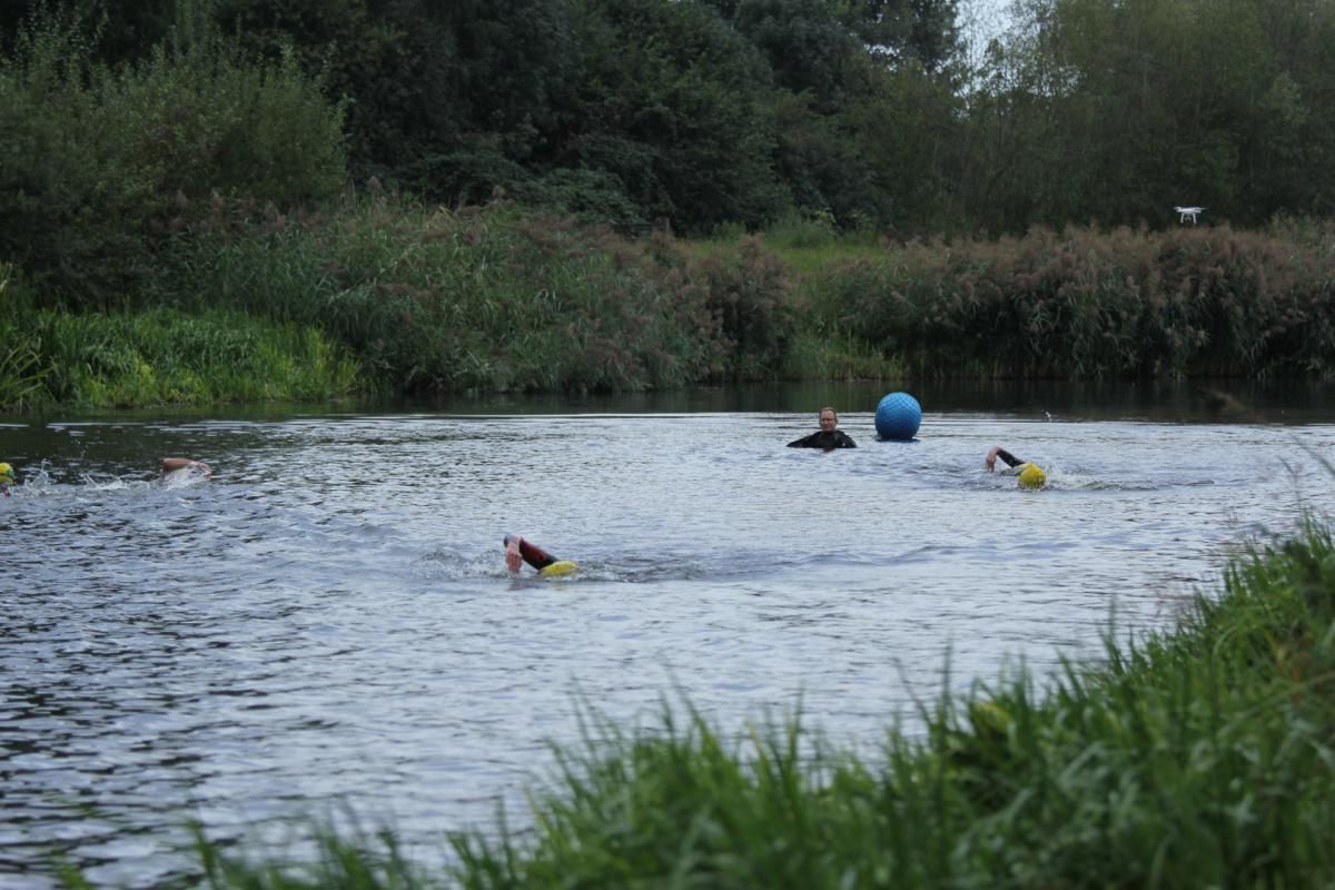 Een groep mensen zwemt in een rivier.