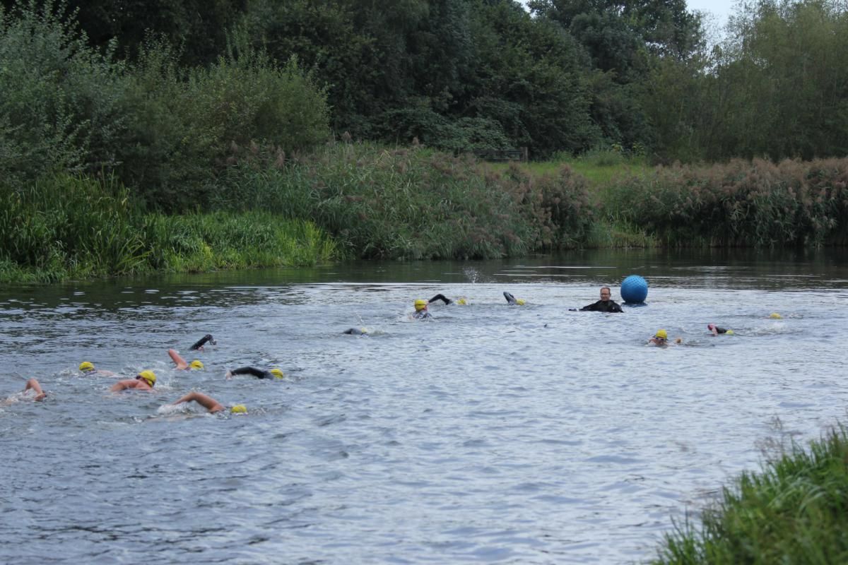 Een groep mensen zwemt in een rivier.