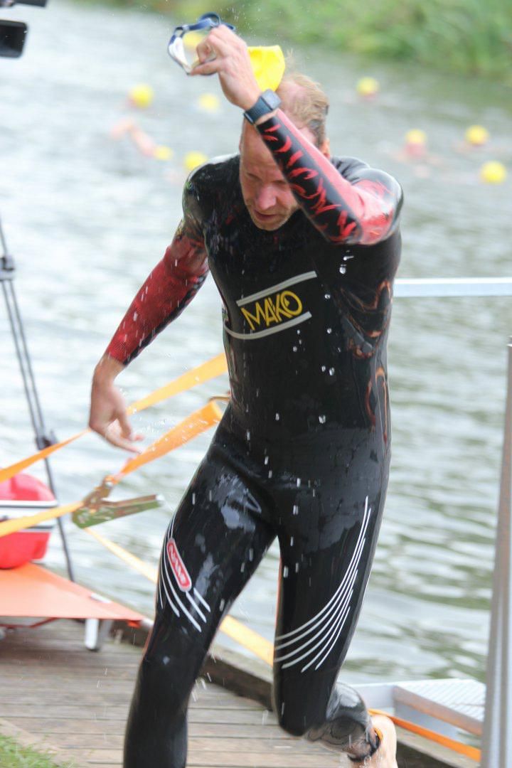 Een man in een wetsuit met het woord mad op zijn shirt