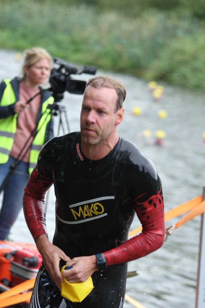 Een man in een wetsuit met het woord mad erop