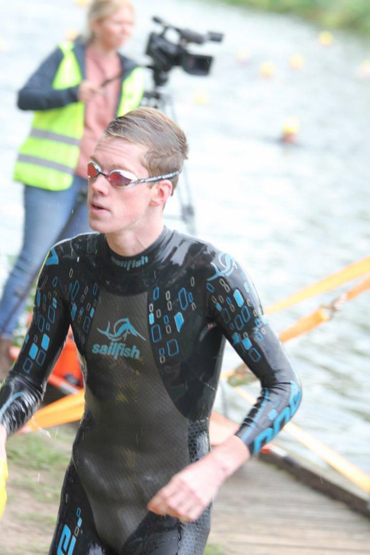 Een man in een wetsuit loopt naar het water