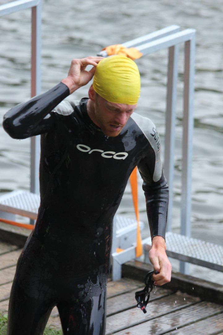 Een man in een orka-wetsuit maakt zich klaar om te zwemmen