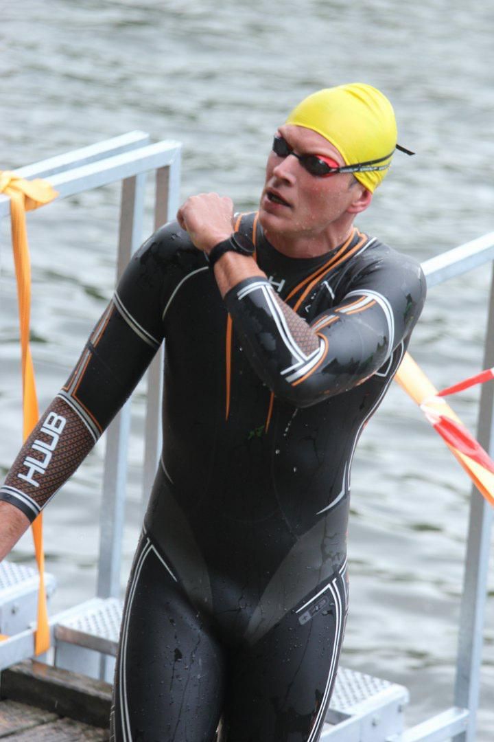Een man in een wetsuit met het woord hub op zijn arm