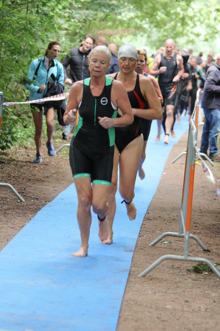 Een groep mensen rent op een blauwe mat.